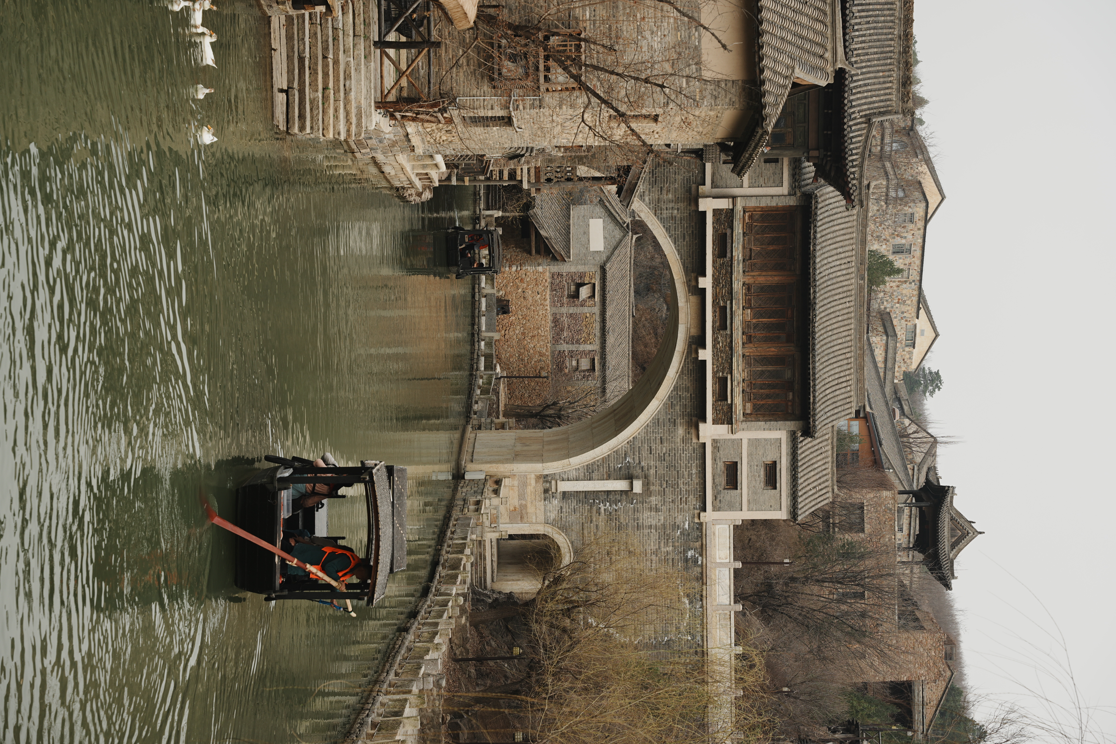 traditional chinese boat paddling through a man made river