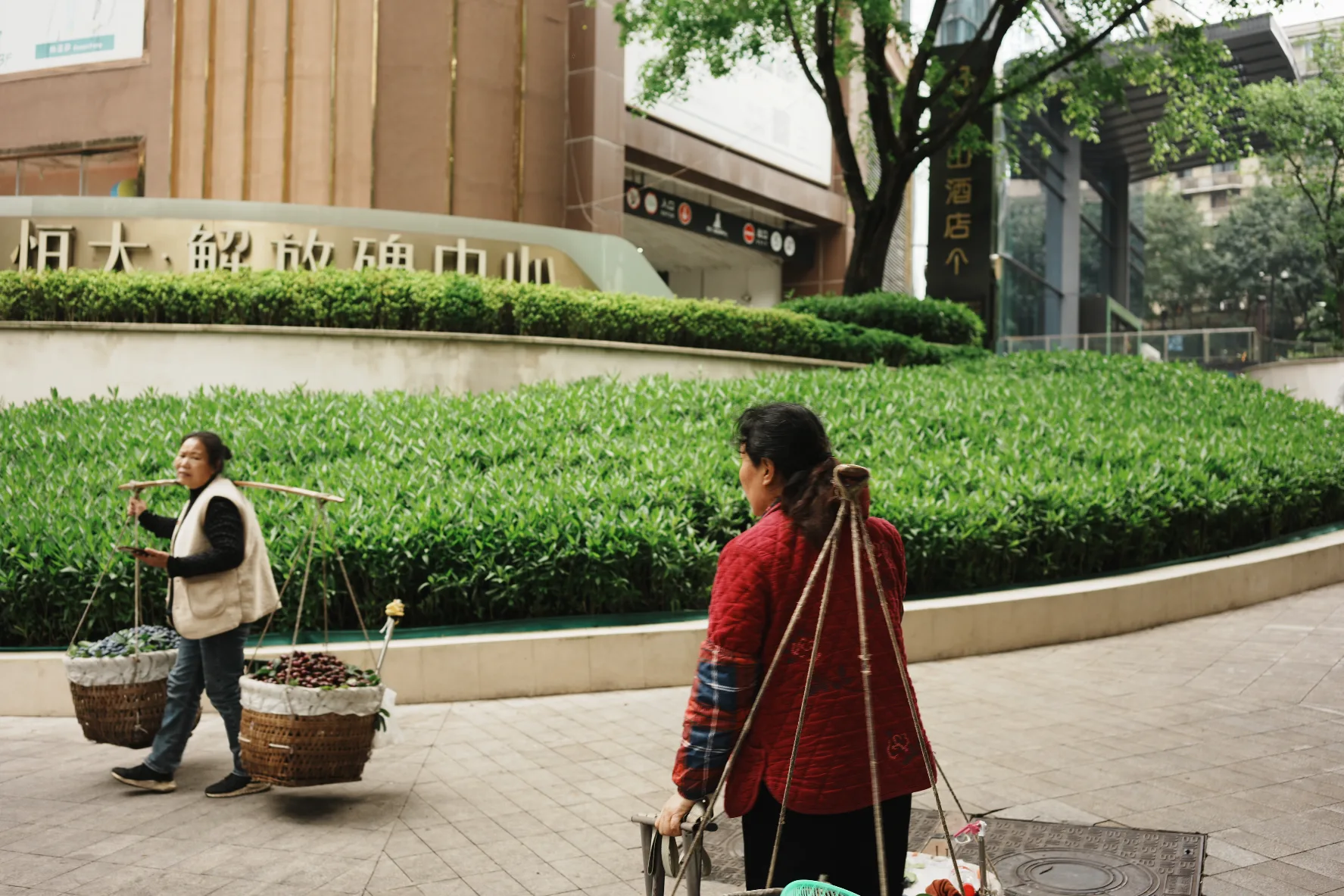 two women carrying baskets of vegetables