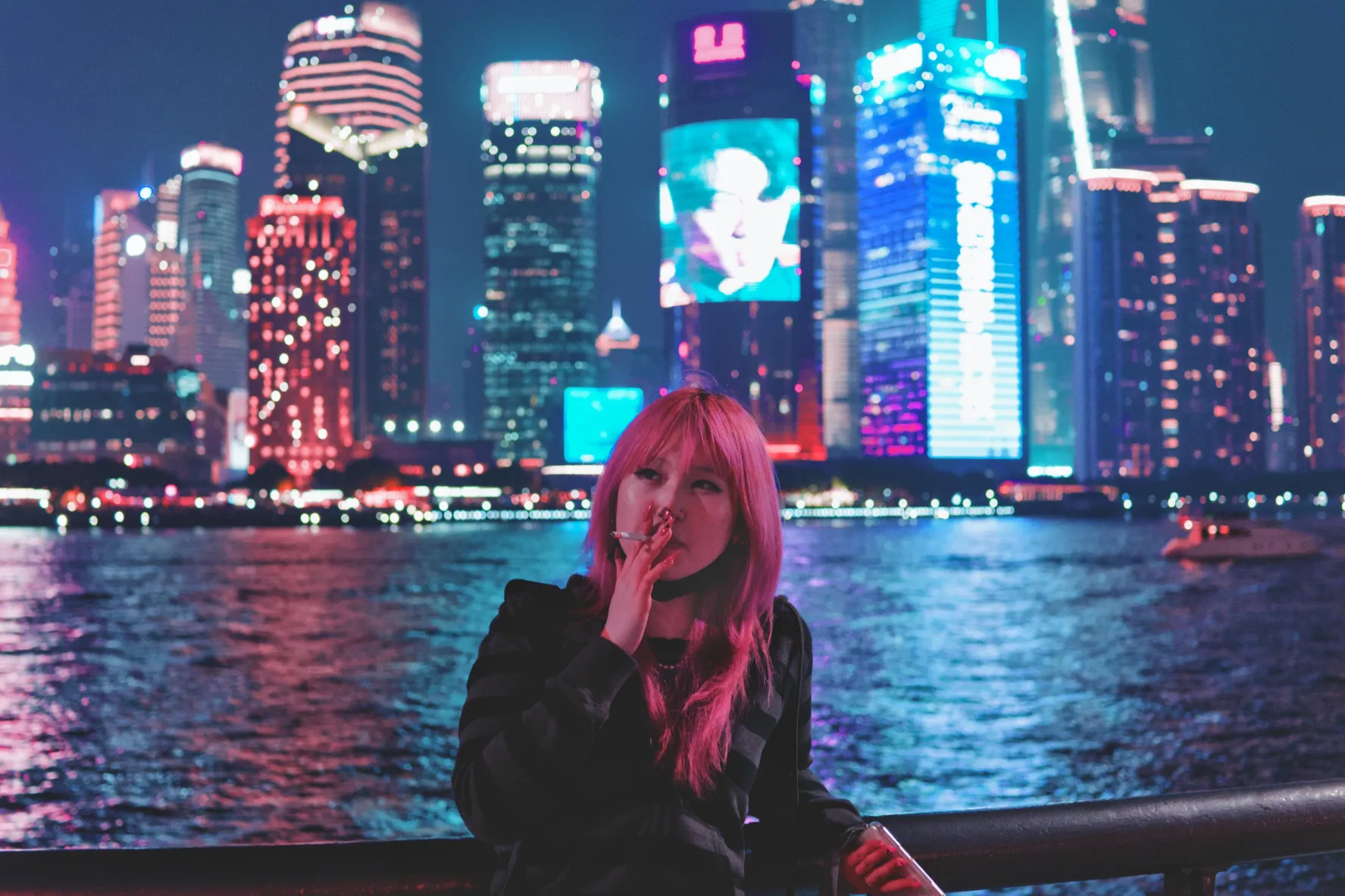 woman smoking a cigarette against the bund in shanghai